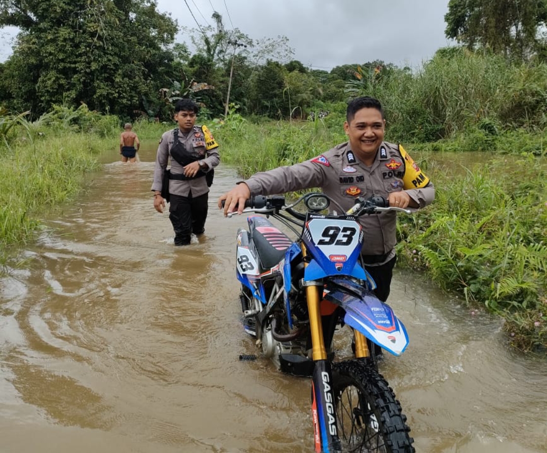 Pantang Menyerah untuk Datangi TPS, Personel Pam Polres Melawi Dorong Sepeda Motor Saat Banjir